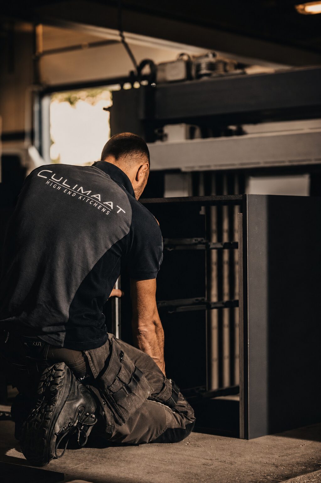 Culimaat vakman monteert een keukenkast in het atelier
