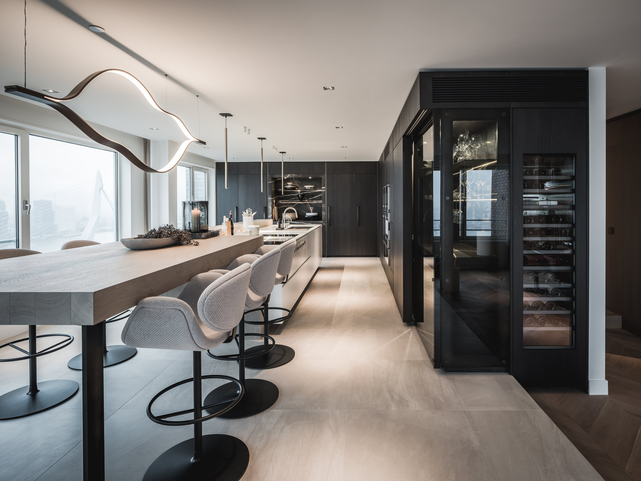 Penthouse keuken met lange houten bartafel en uitzicht over de stad