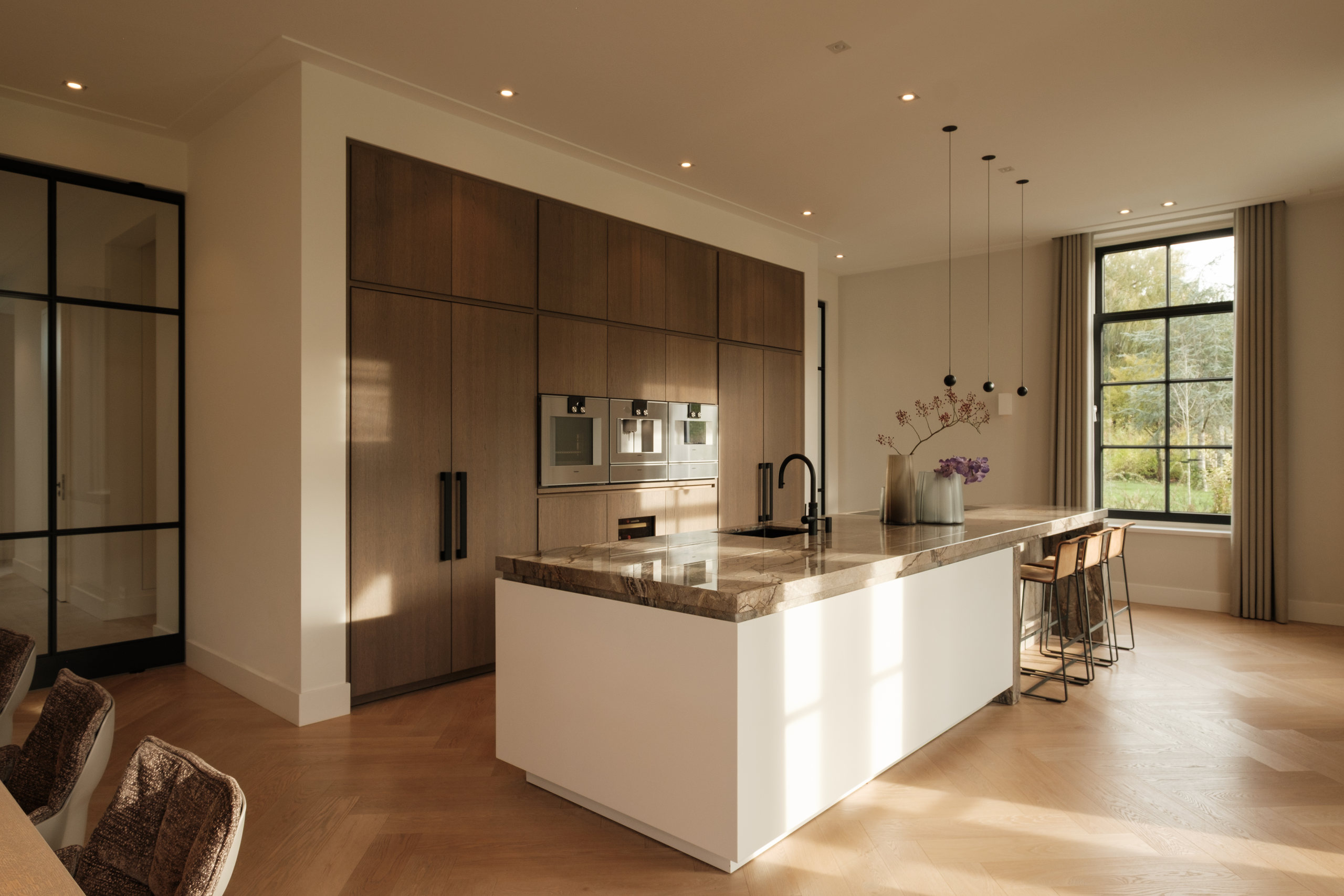 Warme keuken met notenhouten kastenwand, wit kookeiland en marmeren werkblad