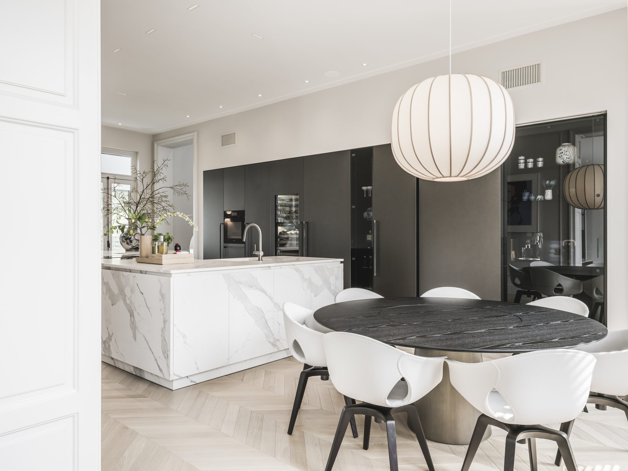 Eetkamer met ronde tafel naast de lichte Culimaat keuken