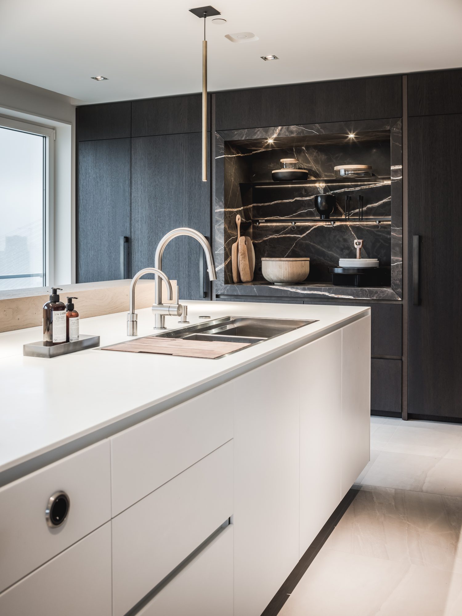 Spoeleiland in wit Corian met schuifdeuren in de wand erachter